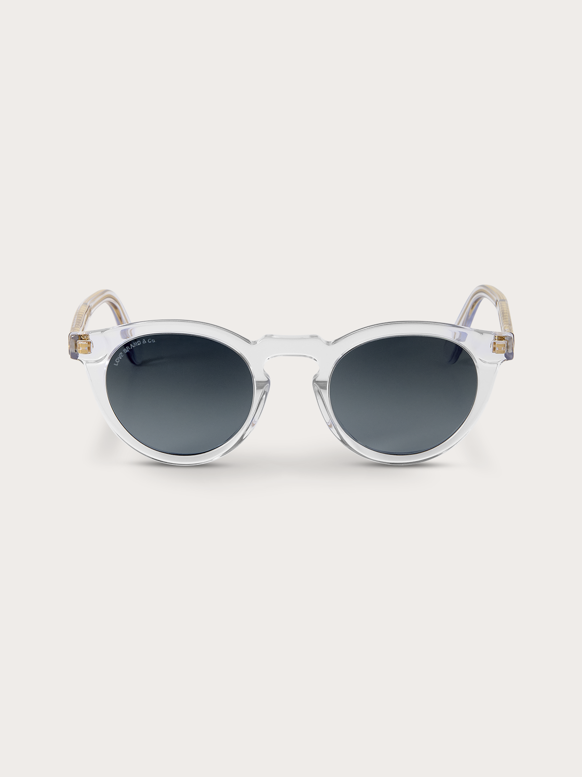 Clear frame sunglasses with dark blue lenses on a light gray background