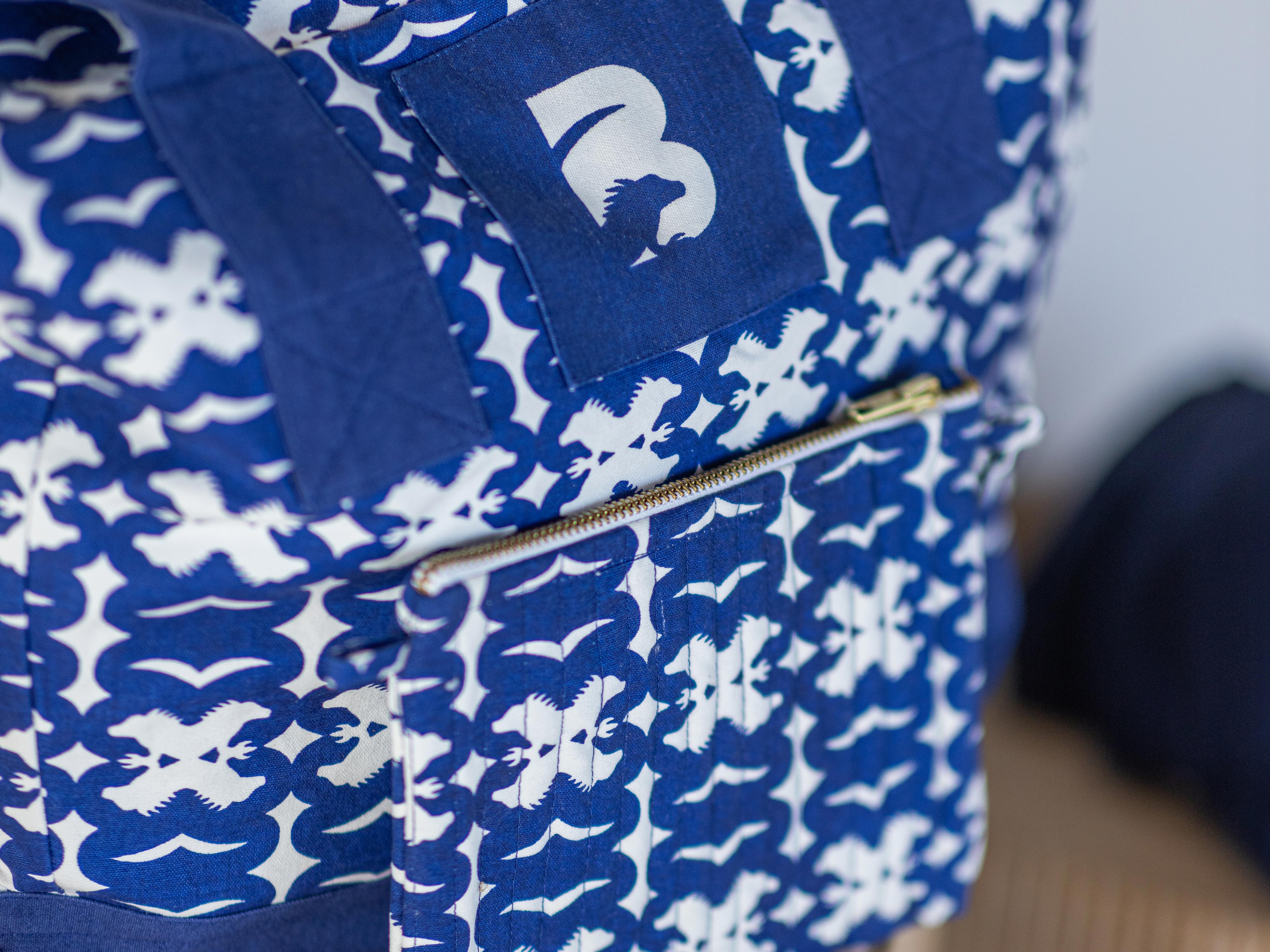 Blue and white patterned bag with a visible brand logo.