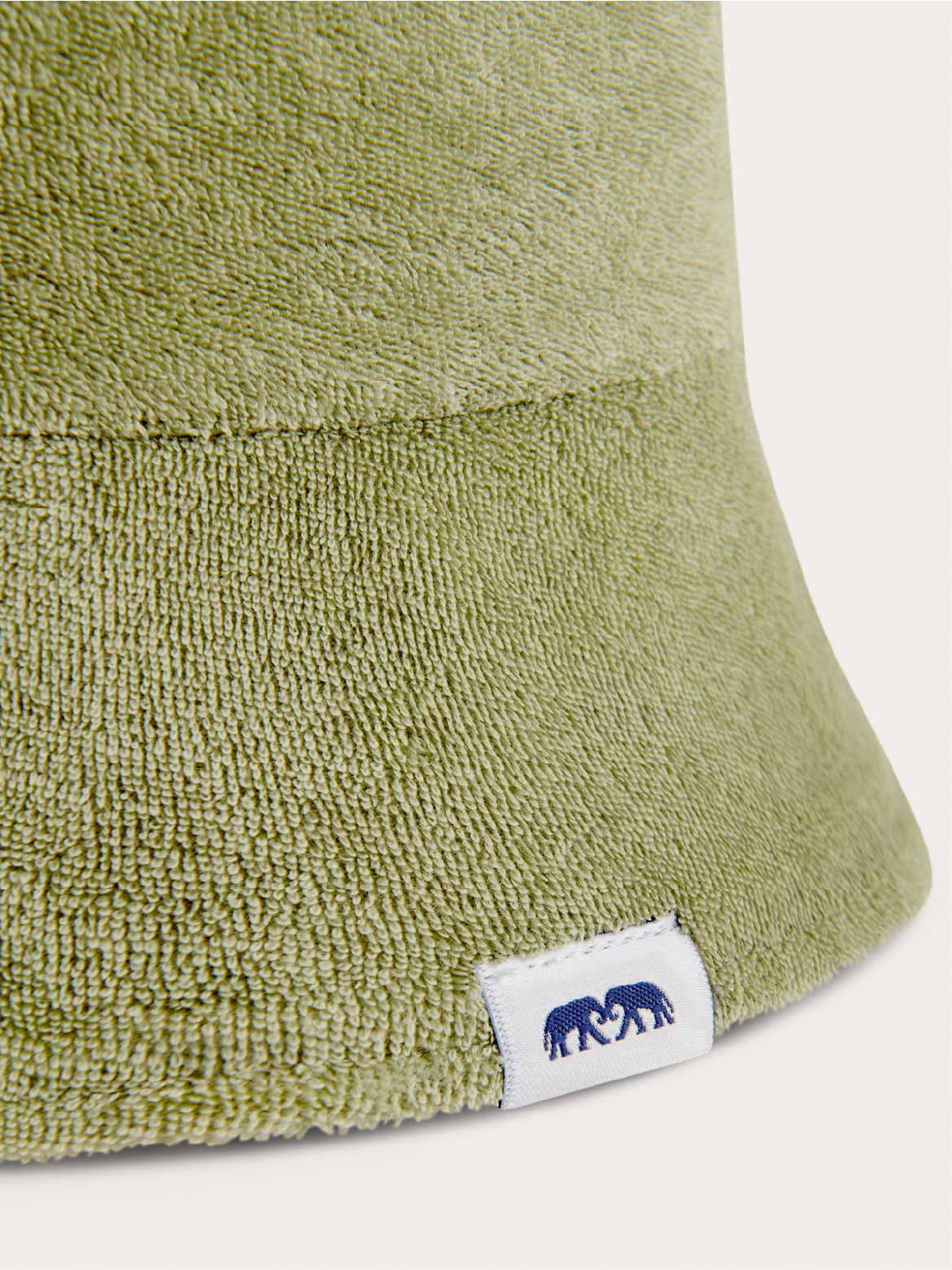 Green terry cloth bucket hat for kids with a brand label on a white background