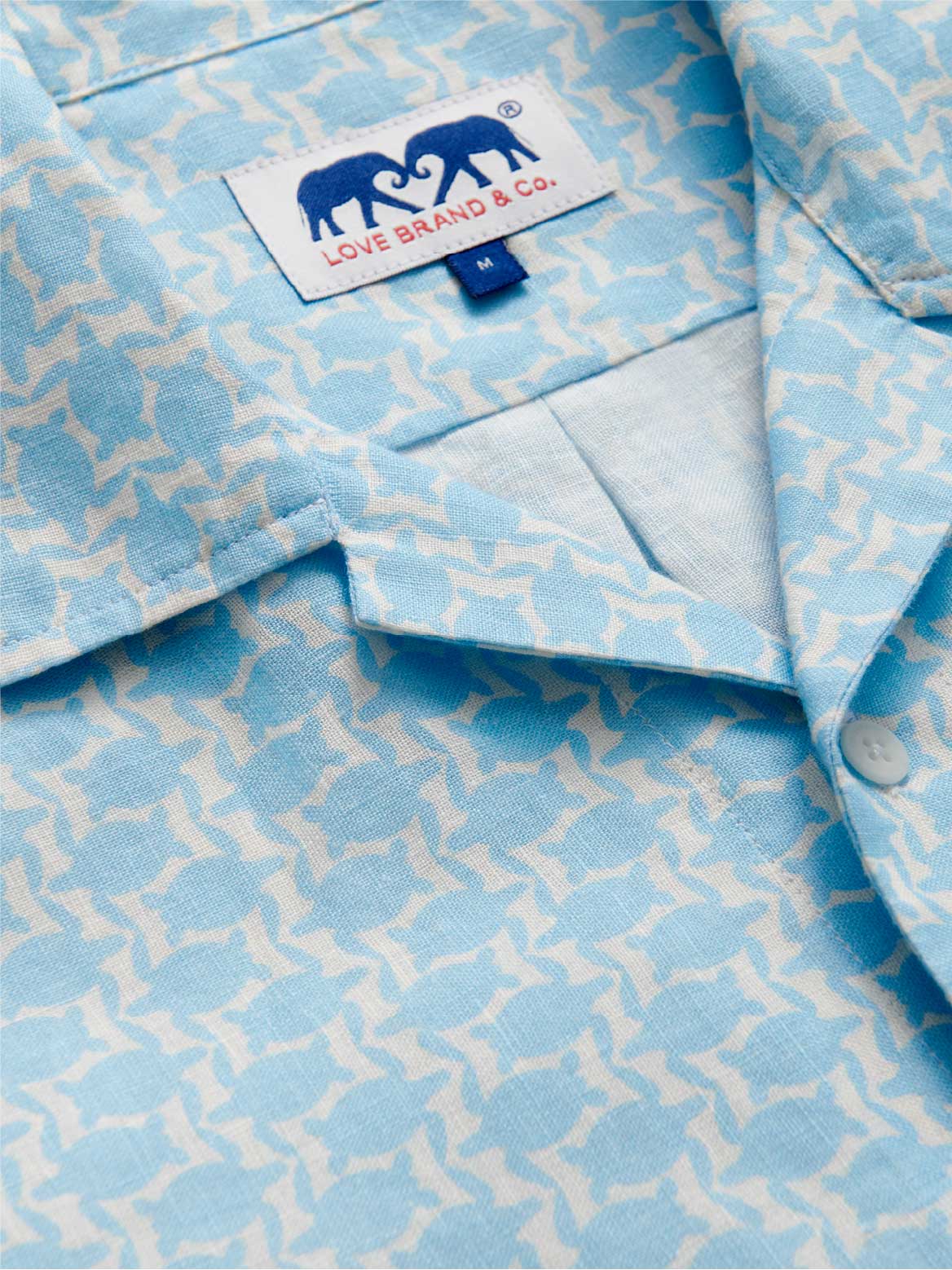 Close-up collar view of mens blue linen shirt with turtle print