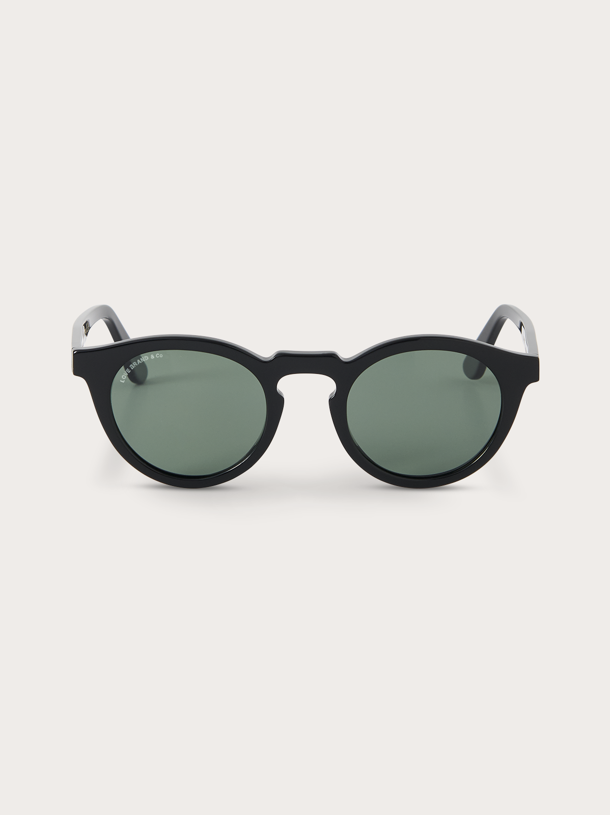 Black sunglasses with green lenses on a white background