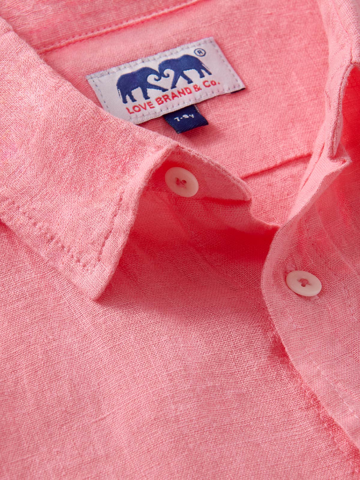 Close-up of a pink shirt for children with a visible love brand label.