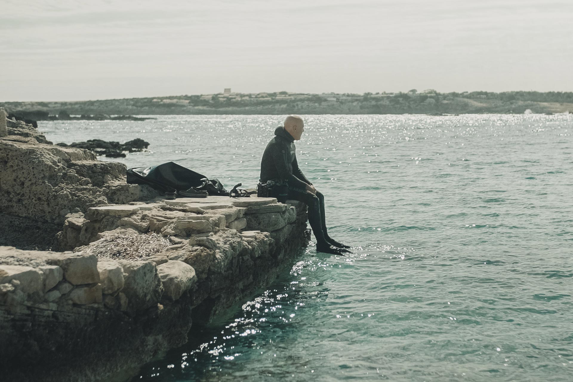 Manu San Felix conservation expert sits on the beach overlooking the water