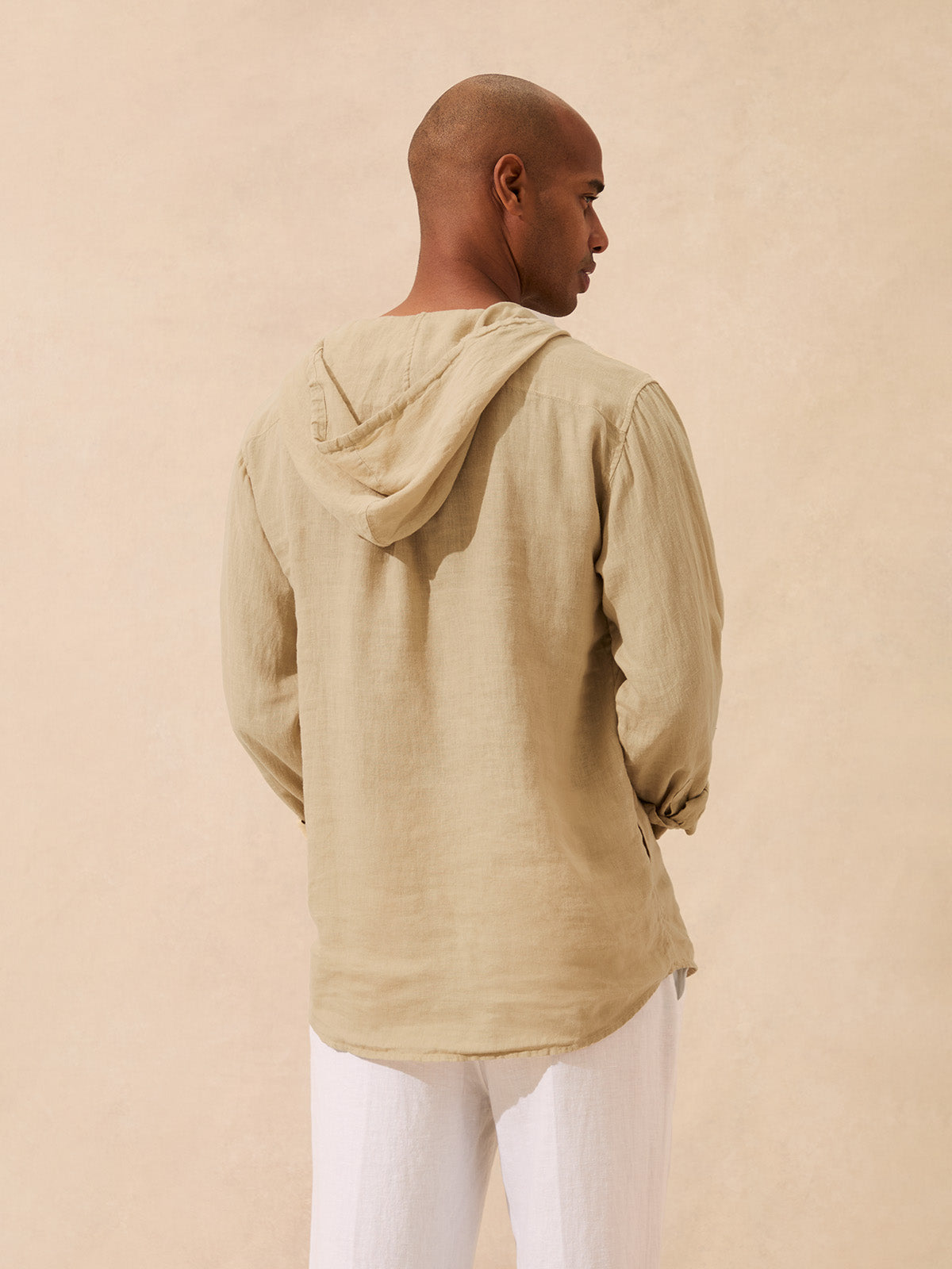 Back view of a man wearing a beige linen hoodie