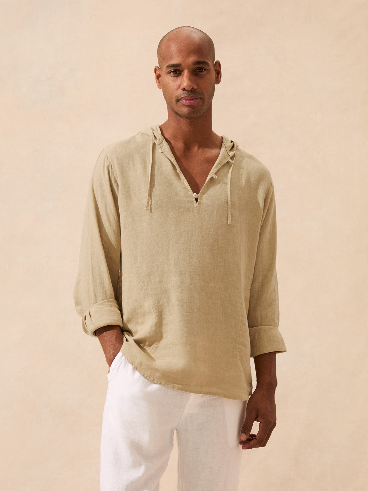 Front view of a man wearing a beige linen hoodie