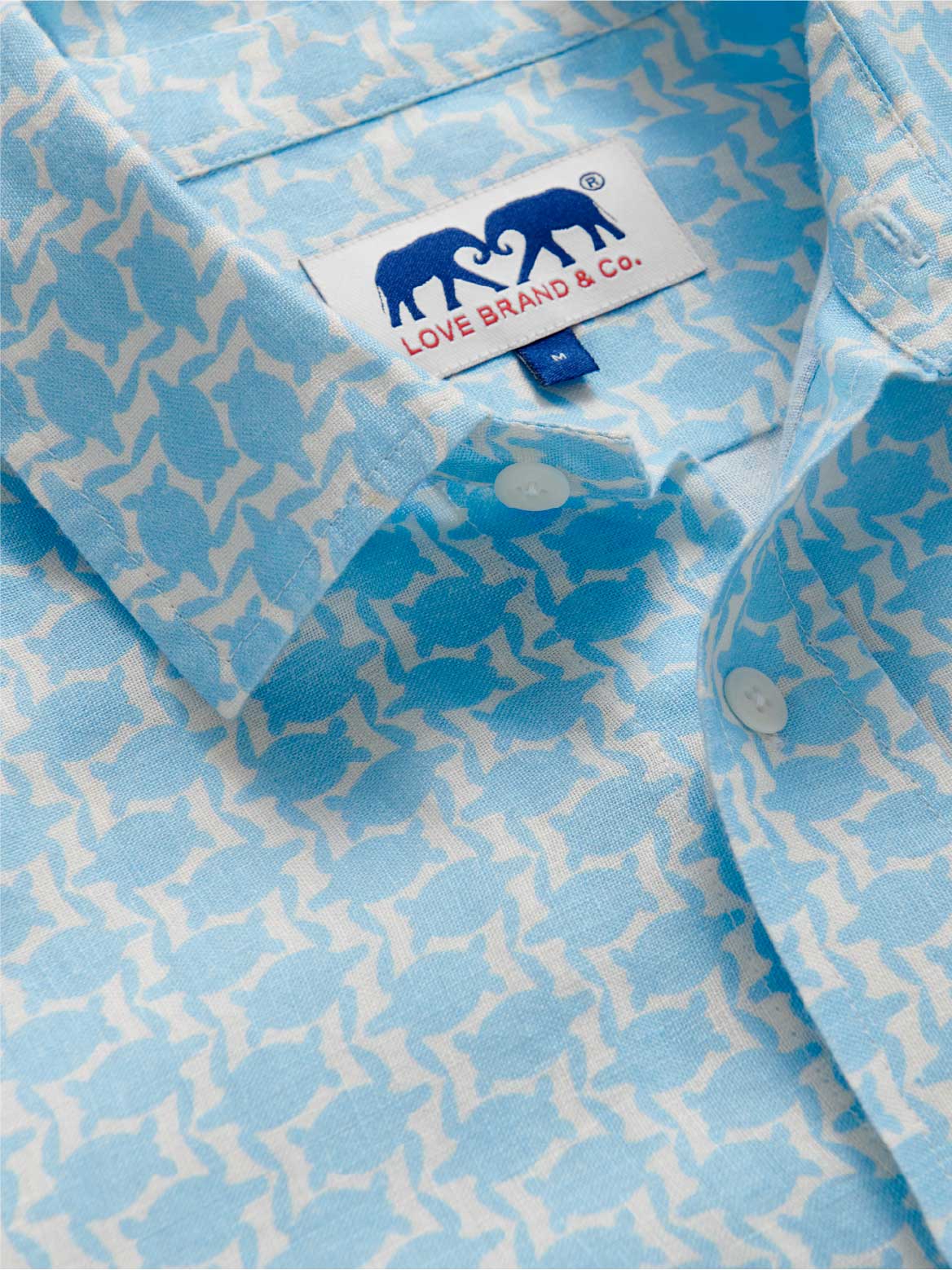 Detailed view of blue mens linen shirt with turtle print.
